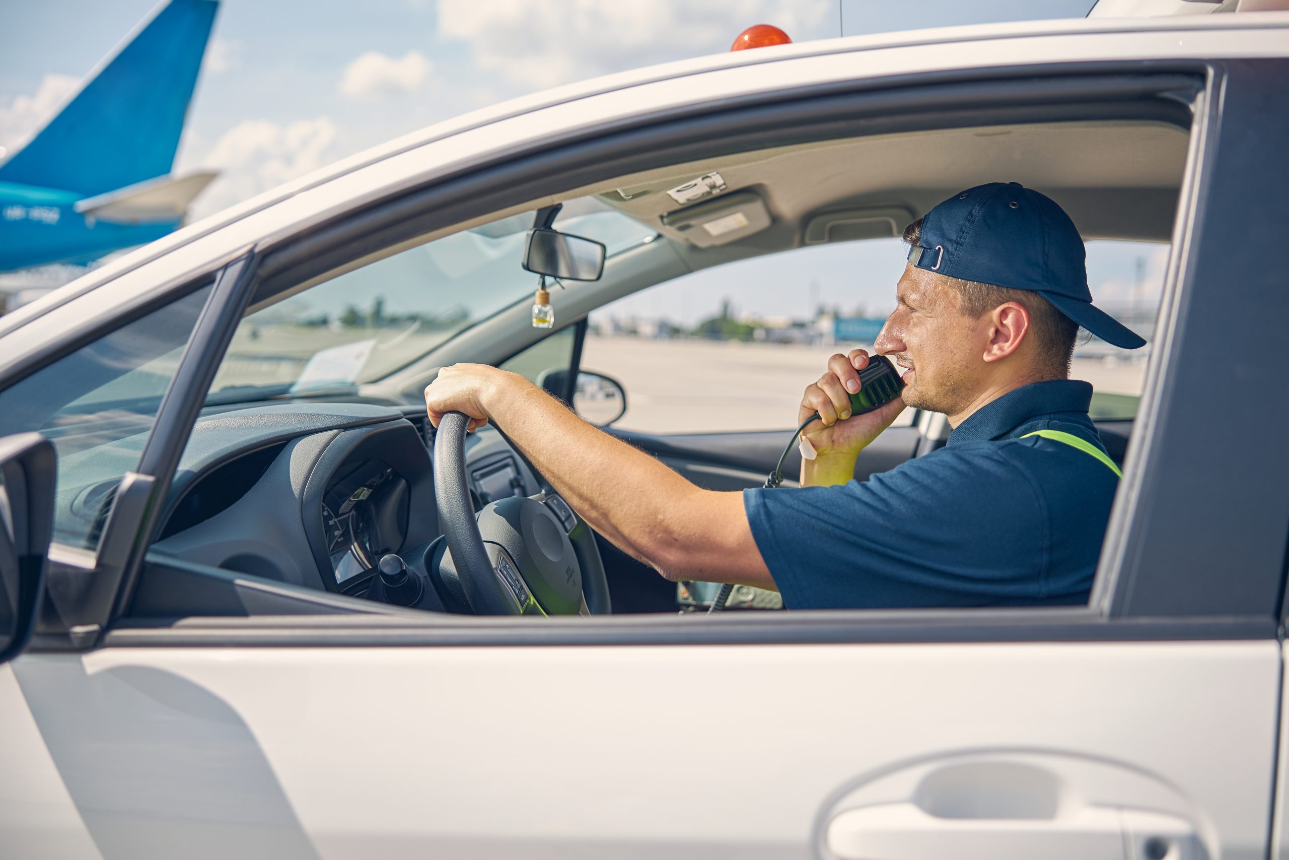 Airport worker in uniform sitting in the car